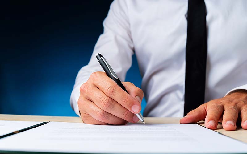 man signing a document