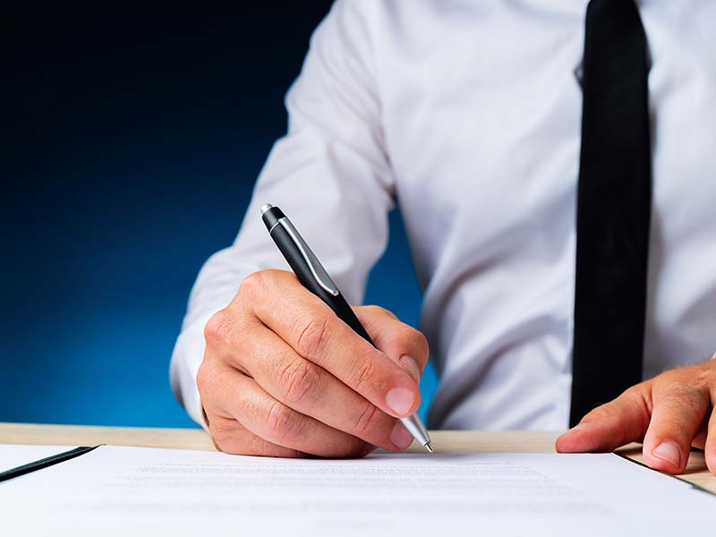 man signing a document